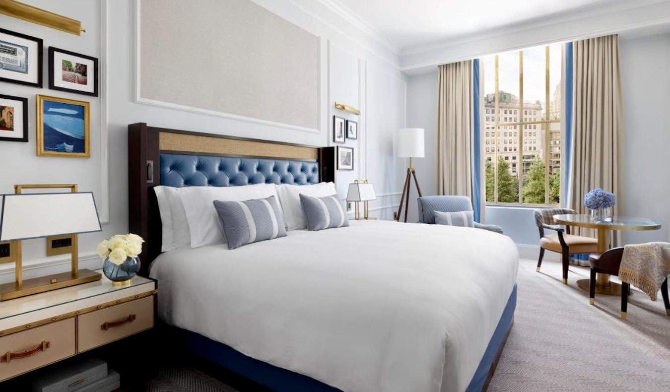 Luxurious and spacious hotel room at The Langham, Boston, featuring elegant furniture and large windows.