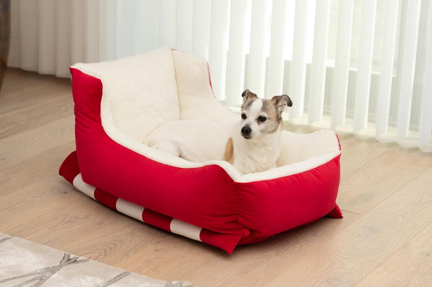Sleigh-shaped dog bed with red velvet and faux fur.