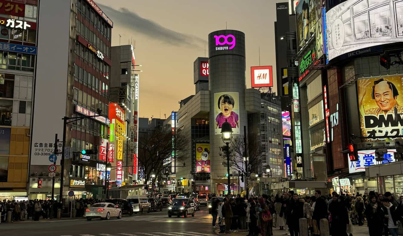 Tokyo intersection at night with bright billboards