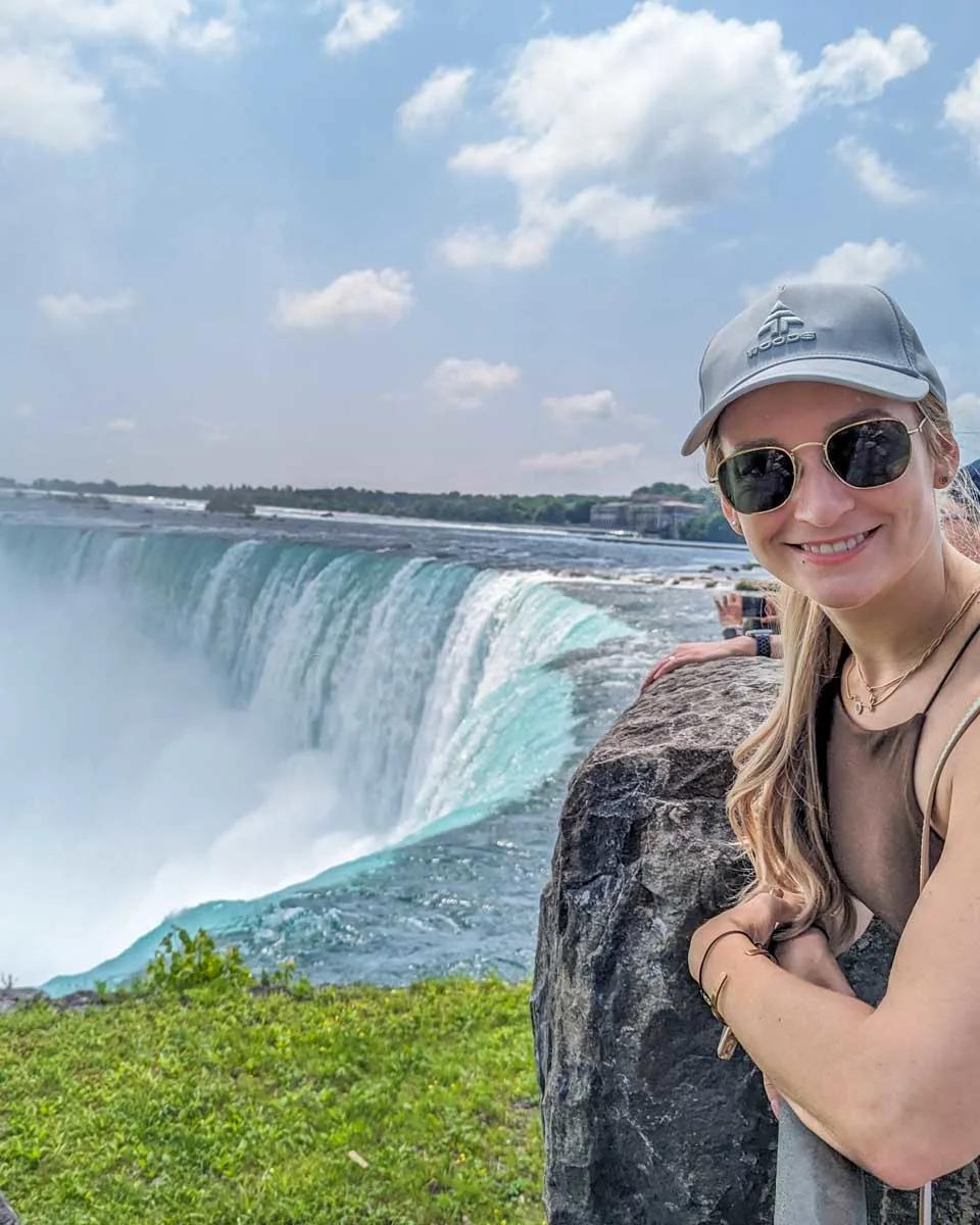Woman leaning over the railing on the Canadian side of Niagara Falls, booked via Viator